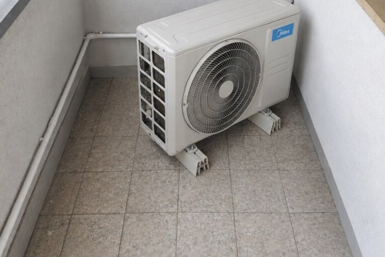 Ten sam balkon po sprzątaniu — umyte płytki i czysta obudowa klimatyzatora